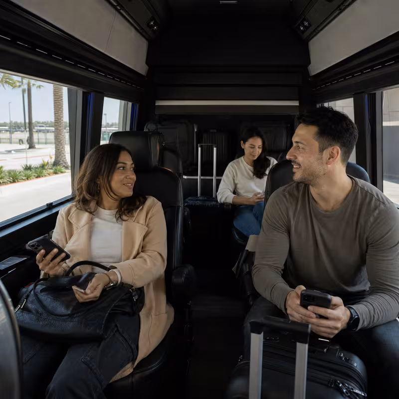 Passengers loading luggage while boarding an Lakewood group shuttle