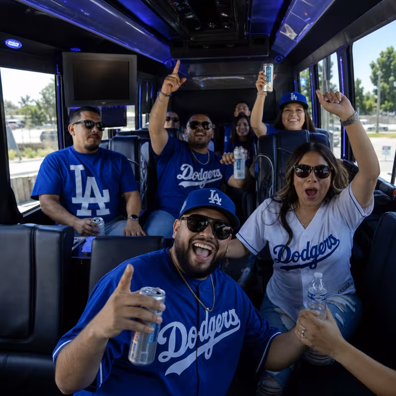 Group boarding a white charter bus for Sporting Event Transportation transportation in Lakewood
